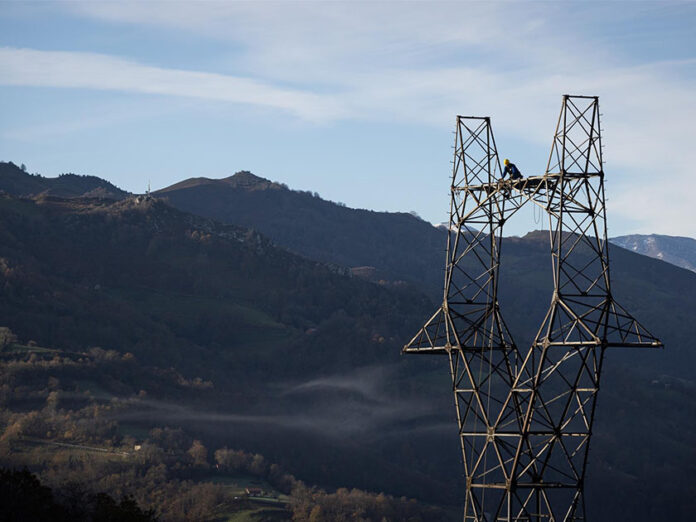 una persona trabaja en una torre de alta tensión